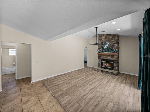 unfurnished living room with a ceiling fan, wood finished floors, a fireplace, and lofted ceiling