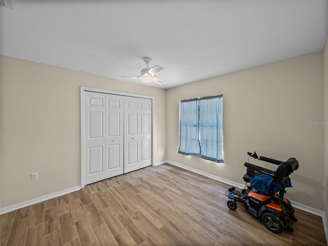 unfurnished bedroom with a closet, wood finished floors, baseboards, and ceiling fan