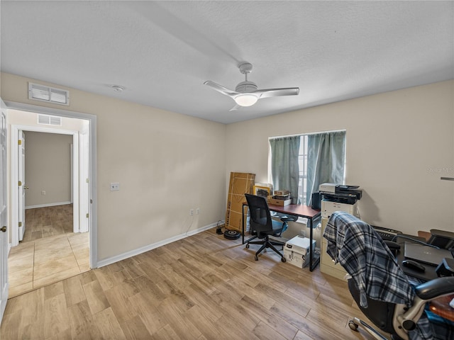 office space with a ceiling fan, visible vents, and light wood-style floors