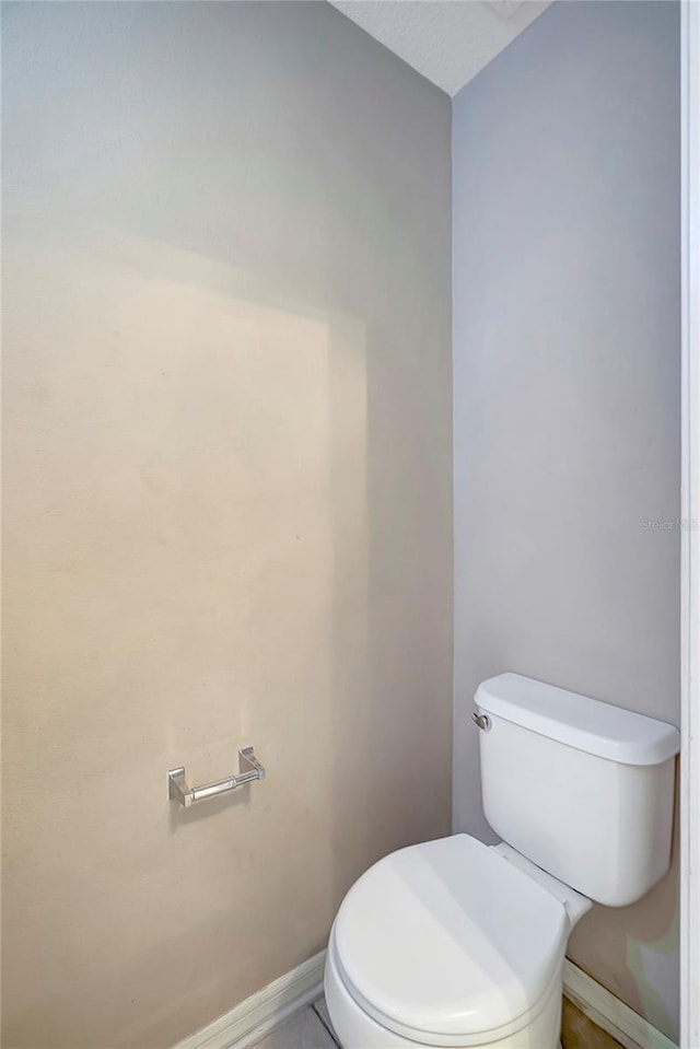bathroom featuring baseboards and toilet
