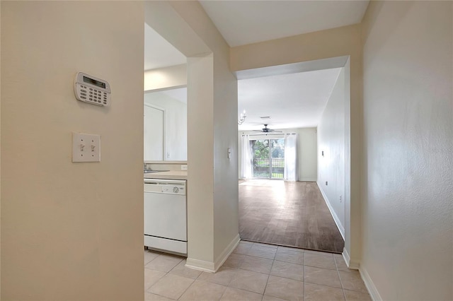 hallway featuring baseboards and light tile patterned floors