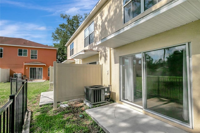 view of home's exterior with central air condition unit, fence, and stucco siding