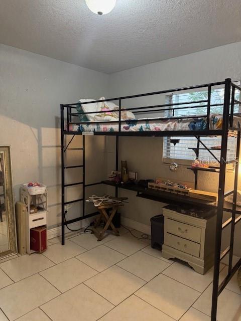 3713 E Clifton St, Tampa, FL 33610 - bedroom featuring light tile patterned floors and a textured ceiling