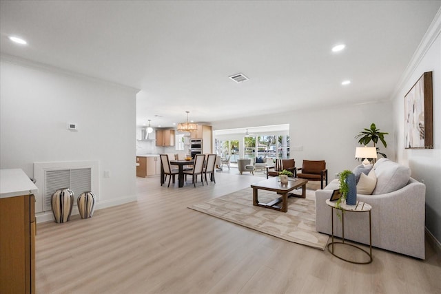 living room featuring light wood-type flooring, recessed lighting, crown molding, and visible vents