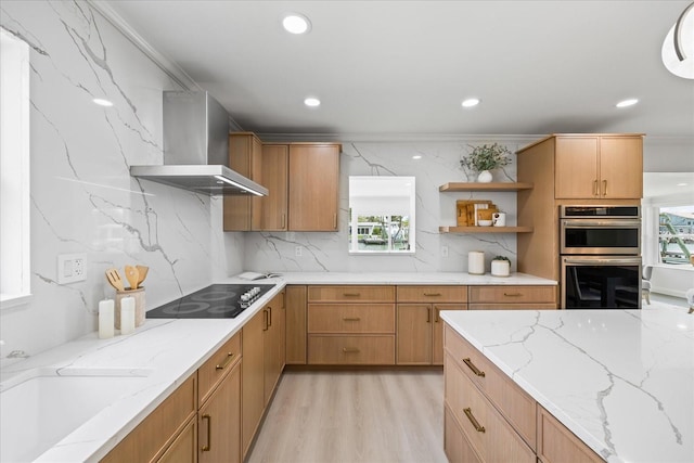 kitchen with open shelves, double oven, black electric stovetop, wall chimney exhaust hood, and a wealth of natural light