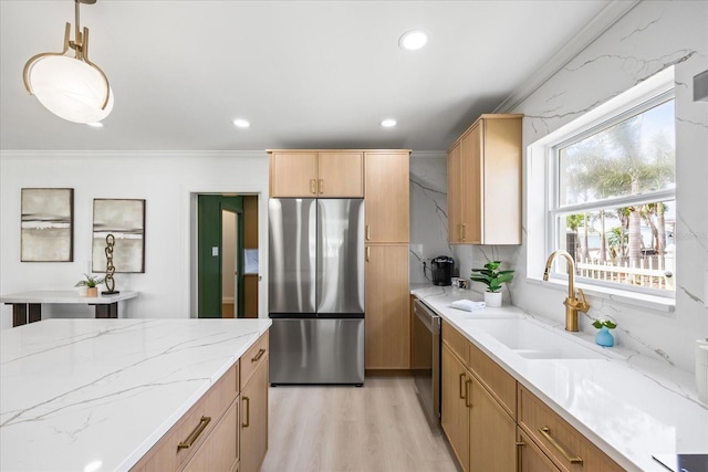 kitchen featuring light stone countertops, appliances with stainless steel finishes, a sink, light wood finished floors, and recessed lighting
