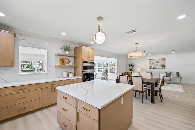 kitchen with plenty of natural light, stainless steel double oven, visible vents, light wood-style floors, and light brown cabinets