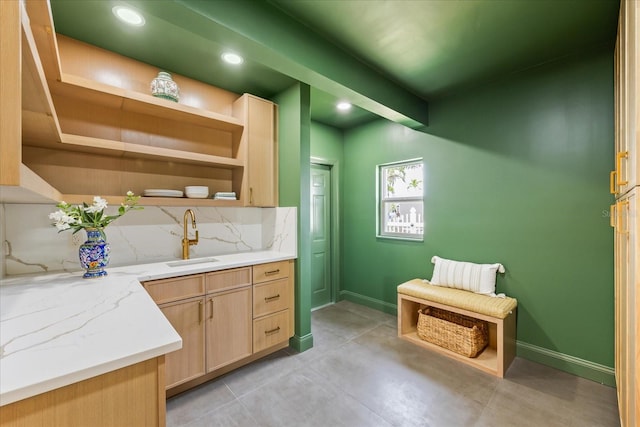 bar featuring decorative backsplash, concrete flooring, baseboards, recessed lighting, and a sink