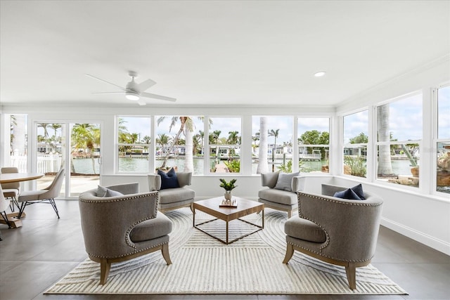 sunroom / solarium with baseboards and a water view