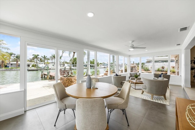 sunroom featuring a water view and visible vents