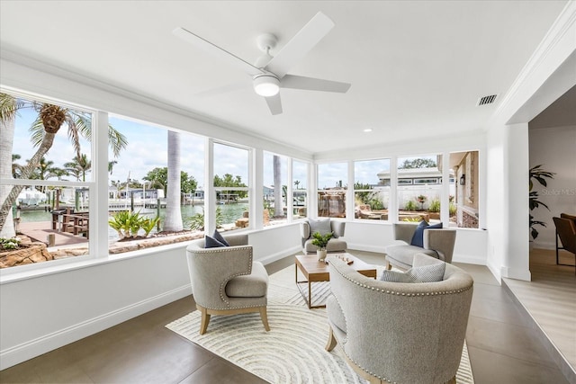 sunroom / solarium with visible vents, a water view, tile patterned floors, and a wealth of natural light