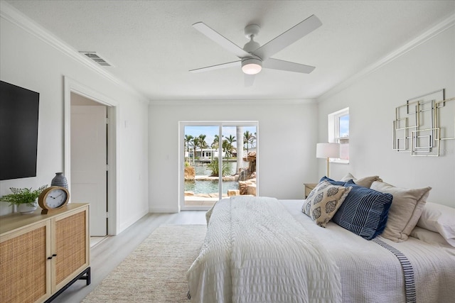 bedroom featuring access to outside, multiple windows, light wood finished floors, visible vents, and ornamental molding