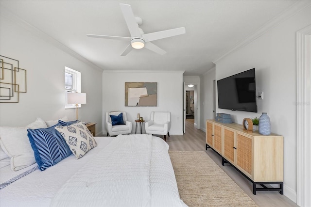 bedroom with crown molding, a ceiling fan, baseboards, and light wood finished floors