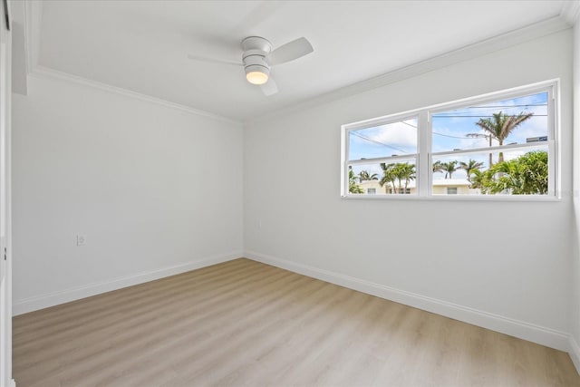 spare room featuring baseboards, ornamental molding, light wood-type flooring, and ceiling fan