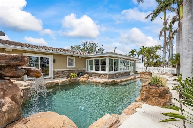 pool with a sunroom and a fenced backyard