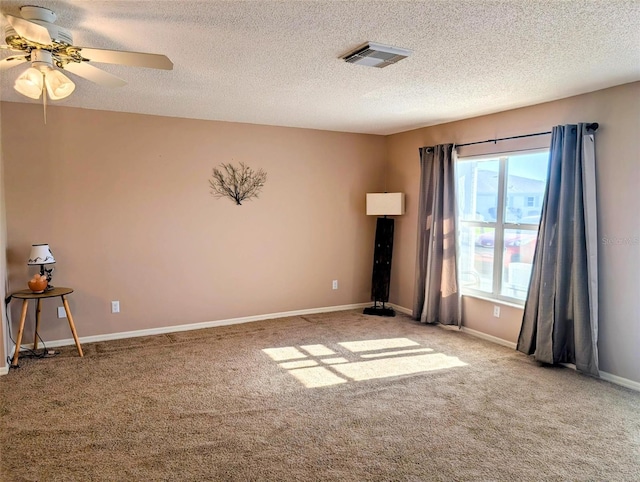 carpeted empty room featuring visible vents, a textured ceiling, ceiling fan, and baseboards