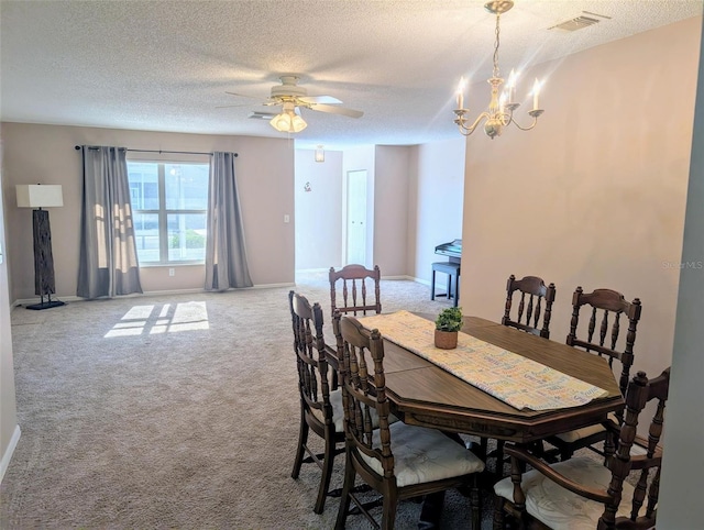 carpeted dining space featuring visible vents, a textured ceiling, and baseboards