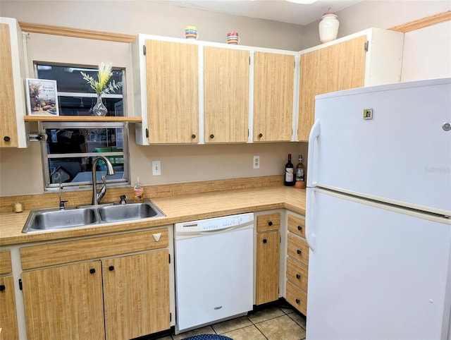 kitchen with a sink, light countertops, light tile patterned floors, and white appliances