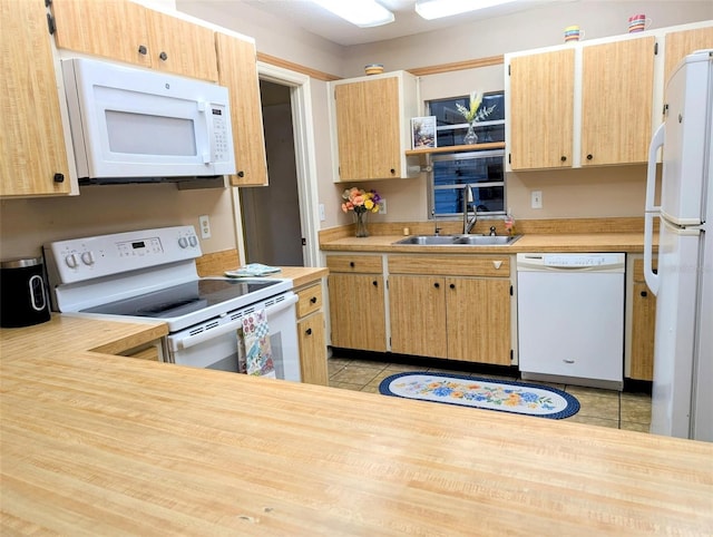 kitchen featuring a sink, light countertops, white appliances, and light tile patterned flooring