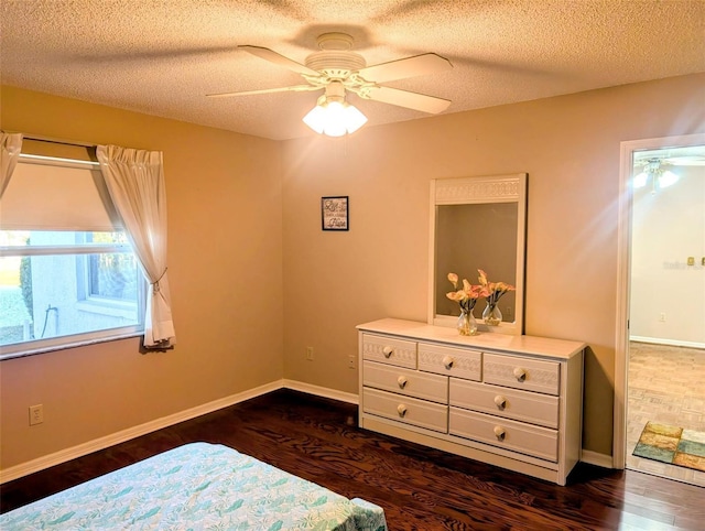 bedroom with dark wood-style flooring, a textured ceiling, baseboards, and a ceiling fan