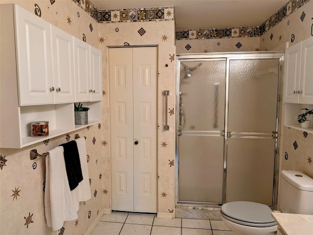 bathroom with tile patterned flooring, a stall shower, and toilet