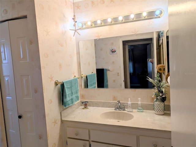 bathroom featuring vanity and wallpapered walls