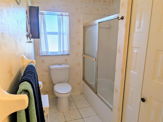 bathroom with tile patterned flooring, toilet, wallpapered walls, baseboards, and bath / shower combo with glass door