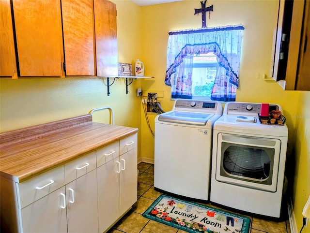 laundry room with cabinet space, light tile patterned floors, and washer and clothes dryer