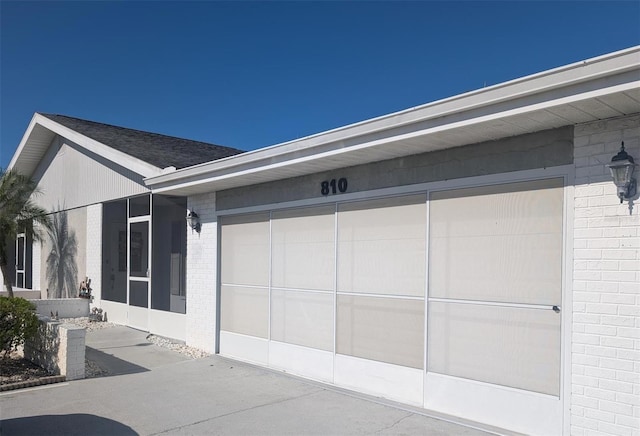 view of side of home with an attached garage and brick siding