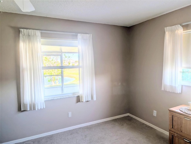 spare room featuring carpet and baseboards