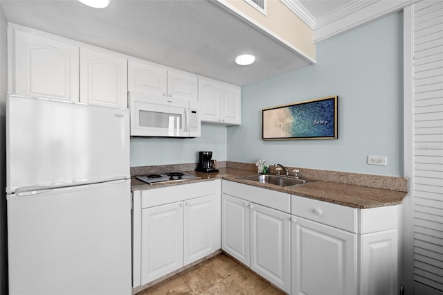 kitchen with white appliances, a sink, white cabinetry, dark countertops, and crown molding