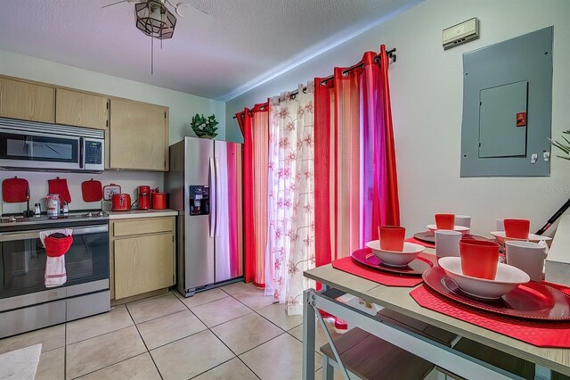 56 Pine Trak Unit 101E, Ocala, FL 34472 - kitchen with electric panel, cream cabinets, light tile patterned floors, light countertops, and stainless steel appliances