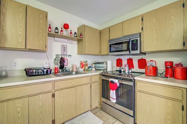 56 Pine Trak Unit 101E, Ocala, FL 34472 - kitchen with open shelves, light countertops, light brown cabinets, stainless steel appliances, and light tile patterned flooring