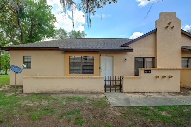 56 Pine Trak Unit 101E, Ocala, FL 34472 - view of front of home with fence, roof with shingles, and stucco siding