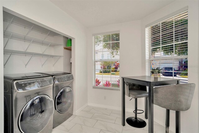 laundry room with independent washer and dryer, light marble finish floors, and baseboards