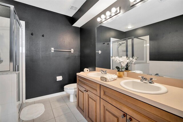 bathroom featuring a stall shower, tile patterned floors, toilet, and double vanity