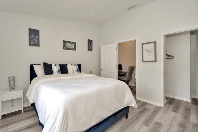 bedroom featuring light wood-style floors, baseboards, and a desk