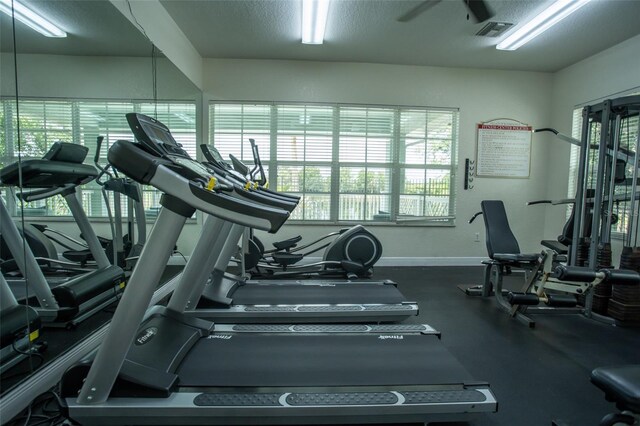 gym featuring baseboards and plenty of natural light