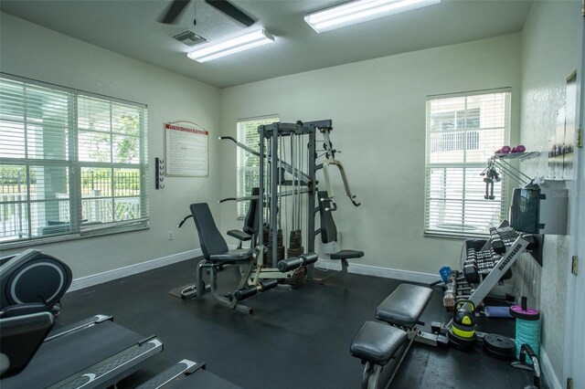 workout area with a ceiling fan and baseboards