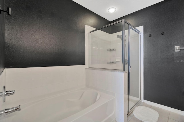 6233 Olivedale Dr, Riverview, FL 33578 - full bathroom featuring a bath, a stall shower, tile patterned flooring, a textured wall, and baseboards