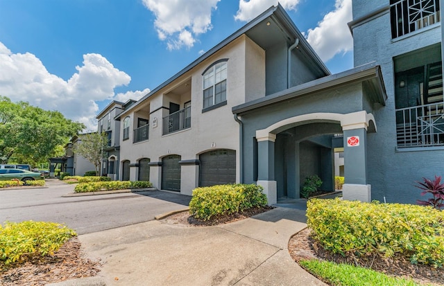 8517 Island Breeze Ln Unit 106, Temple Terrace, FL 33637 - view of front of house featuring concrete driveway, an attached garage, a balcony, and stucco siding