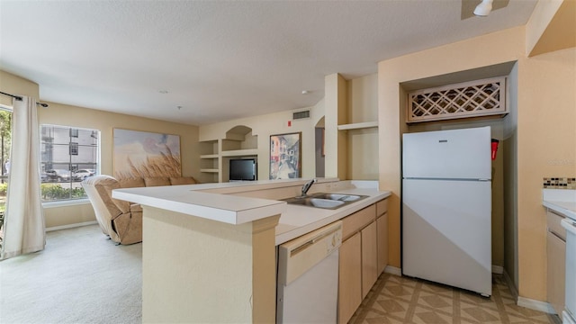 8517 Island Breeze Ln Unit 106, Temple Terrace, FL 33637 - kitchen featuring visible vents, a peninsula, white appliances, light countertops, and a sink