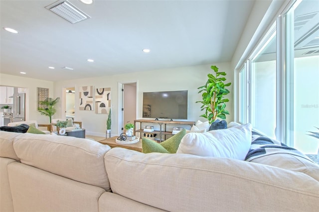living area with visible vents, recessed lighting, and baseboards