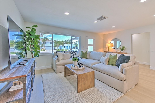 living area with recessed lighting, baseboards, visible vents, and light wood finished floors