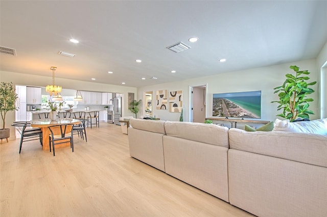 living room featuring recessed lighting, visible vents, a wealth of natural light, and light wood-style flooring