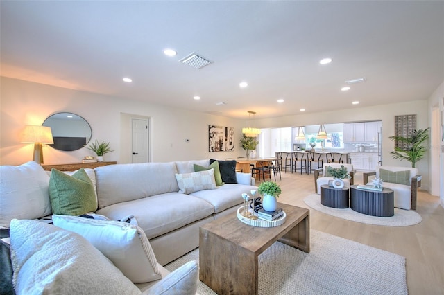 living room featuring recessed lighting, visible vents, and light wood-style flooring