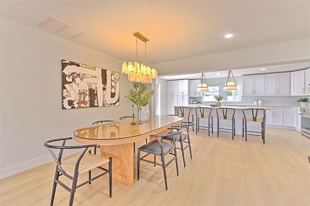 dining space featuring a notable chandelier, recessed lighting, baseboards, light wood-type flooring, and visible vents