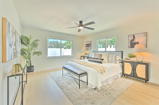 bedroom featuring a ceiling fan, baseboards, and wood finished floors