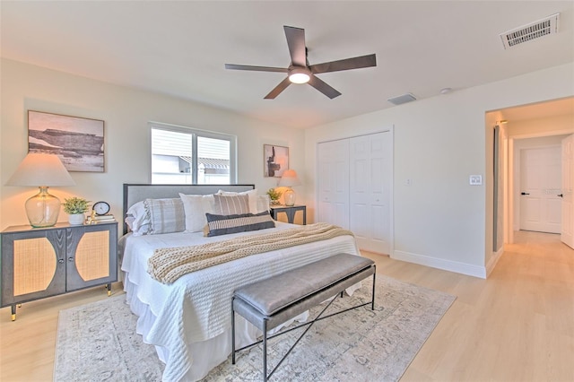 bedroom with a ceiling fan, a closet, light wood-style flooring, and visible vents