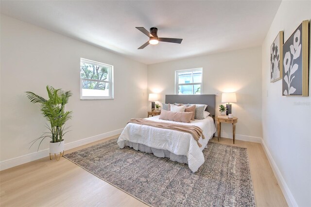 bedroom featuring light wood-style floors, baseboards, and ceiling fan